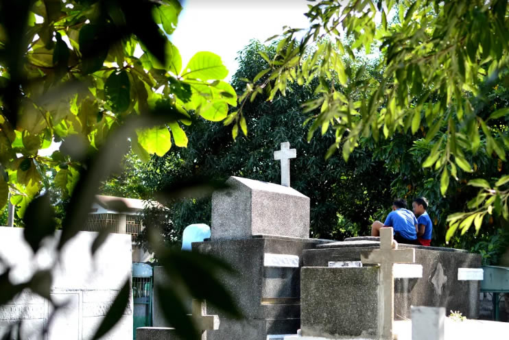 With some of the tombs towering to sometimes 5 crypts high, these two young boys “took to the skies” where they found a perfect spot to relax with those they visited.(NICEFORO BALBEDINA/CBCPNEWS)